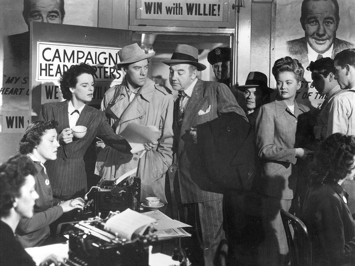 A black-and-white photo of men and women in a campaign's headquarters