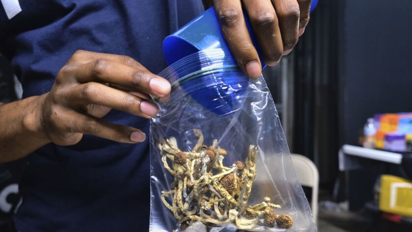 A vendor bags psilocybin mushrooms at a cannabis marketplace in Los Angeles on May 24.