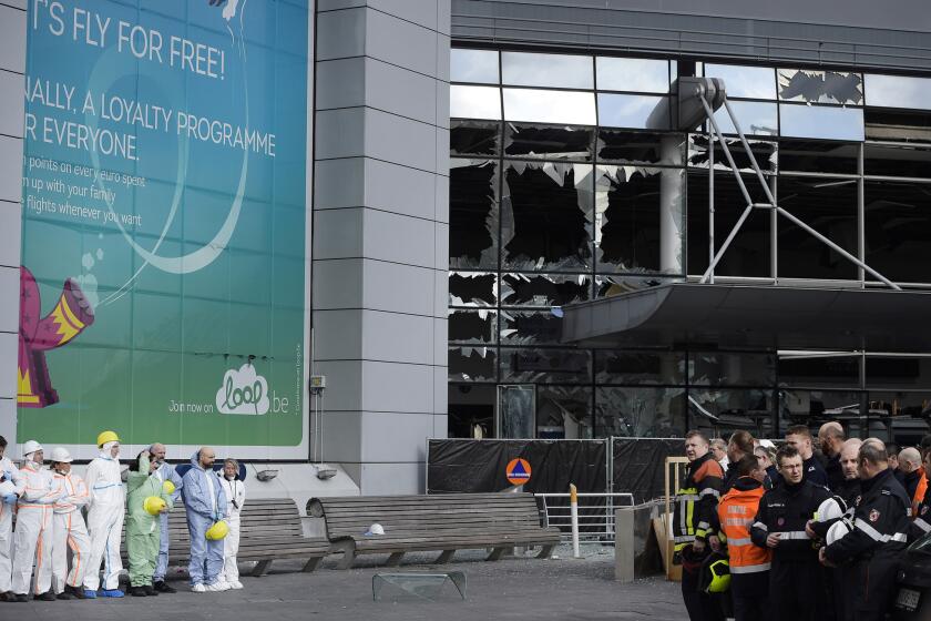 Forensic officers and firefighters gather outside the damaged terminal at Brussels Airport on Wednesday.