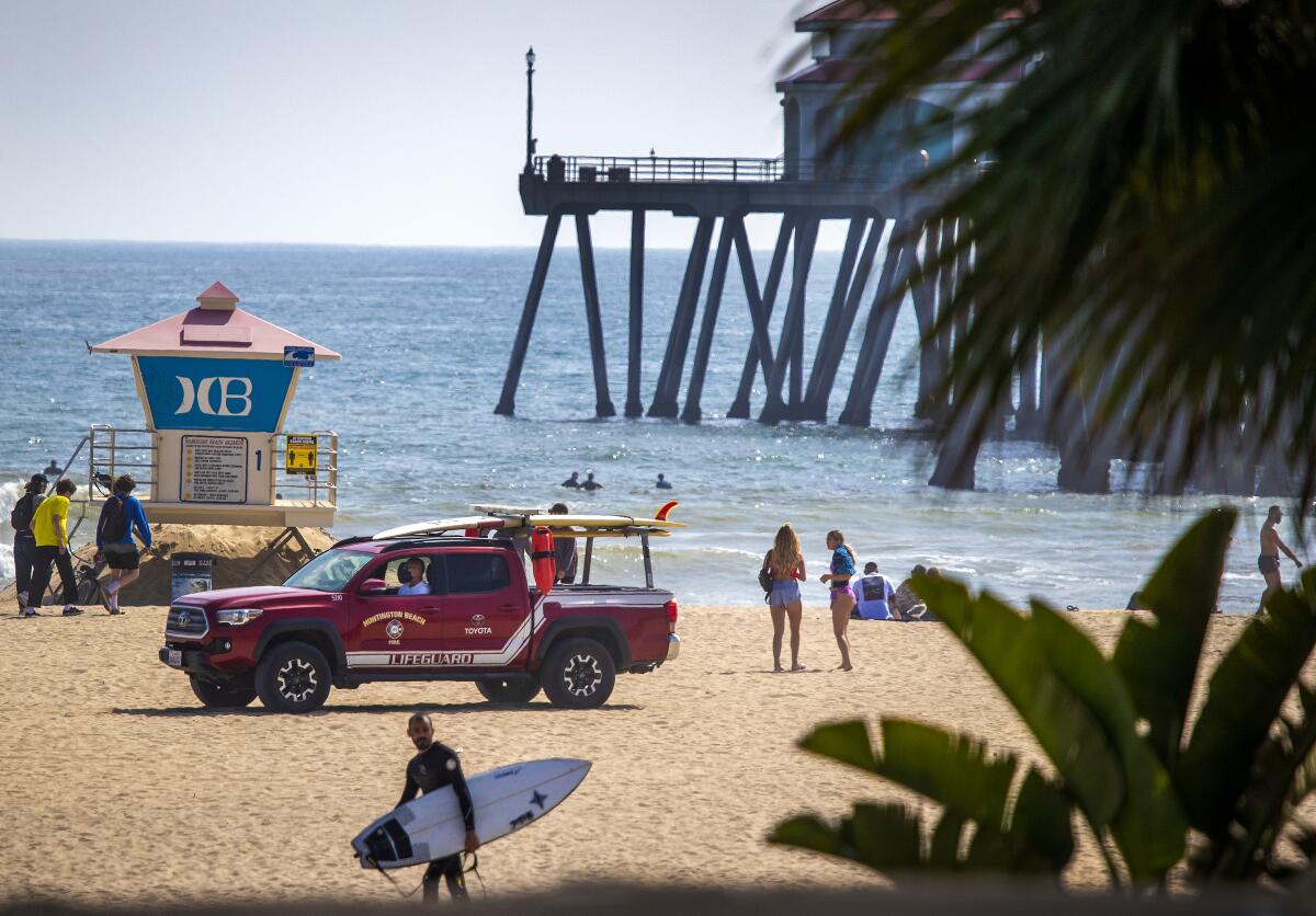 A Huntington Beach lifeguard patrols the beach on Thursday, the last day of open beaches in Huntington Beach after Gov. Gavin Newsom’s closure order.