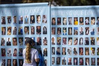 Los Angeles, CA - October 01: A woman presses her face agains the photo of Vanessa Haros, who died of suicide, amidst photos on a memorial posters during the 25th annual "Alive Together: Uniting to Prevent Suicide" that raises funds and awareness for Didi Hirsch's Suicide Prevention Center during a charity walk around Exposition Park in Los Angeles Sunday, Oct. 1, 2023. The community-building event featured walking 2,160 steps in remembrance of the approximately 2,160 lives lost each day worldwide to suicide, pay tribute to survivors, and shine a light on the issue. The event featured inspirational speakers sharing stories and support alongside a resource fair with community-building activities and memorials. (Allen J. Schaben / Los Angeles Times)