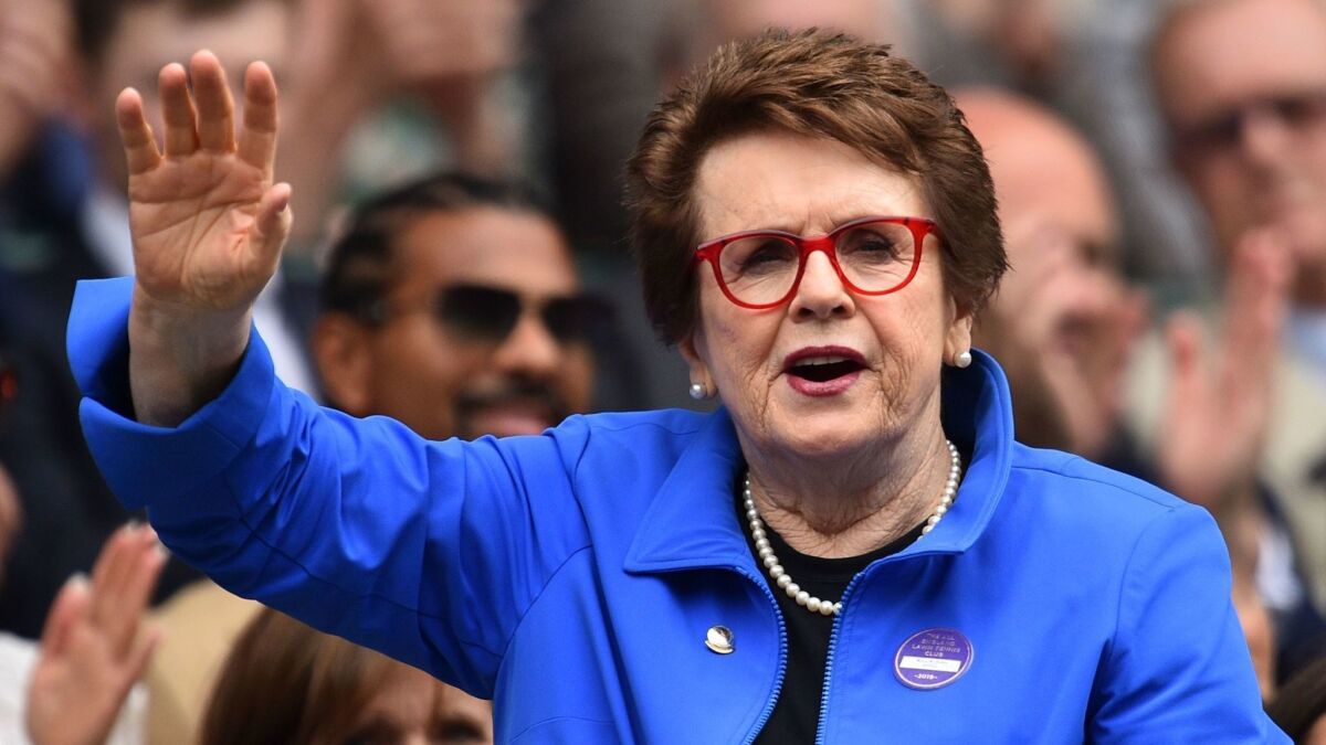 Tennis legend Billie Jean King waves to fans at the All England Tennis Club in Wimbledon on July 6. King says FIFA needs to do the right thing and require equal pay for women's soccer players.
