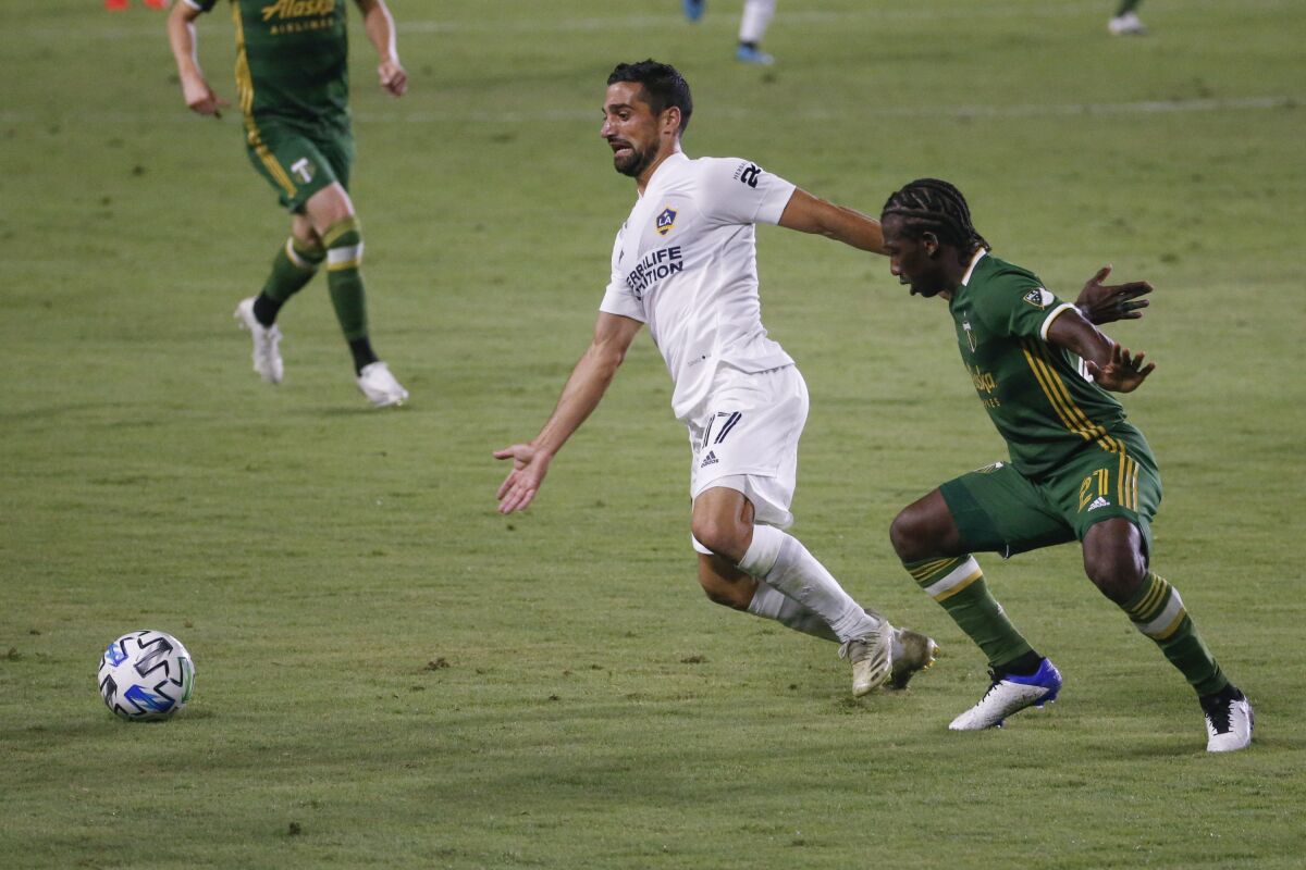 Galaxy midfielder Sebastian Lletget controls the ball in front of Portland Timbers midfielder Diego Chara.