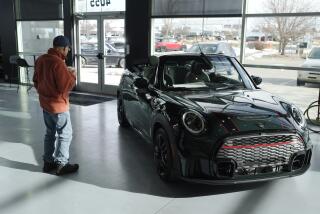 FILE - A man looks at a 2024 Cooper S John Cooper Works convertible at a Mini dealership on Nov. 30, 2023, in Loveland, Colo. Automobile prices, which had been fueling inflation in the U.S., are starting to drop, helping to slow overall consumer price increases and giving buyers hope of getting a deal. (AP Photo/David Zalubowski, File)