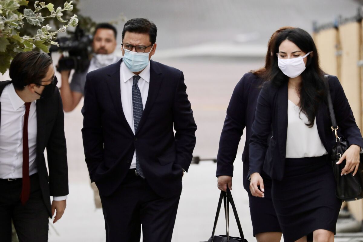 Jose Huizar walks next to two people outside the courthouse