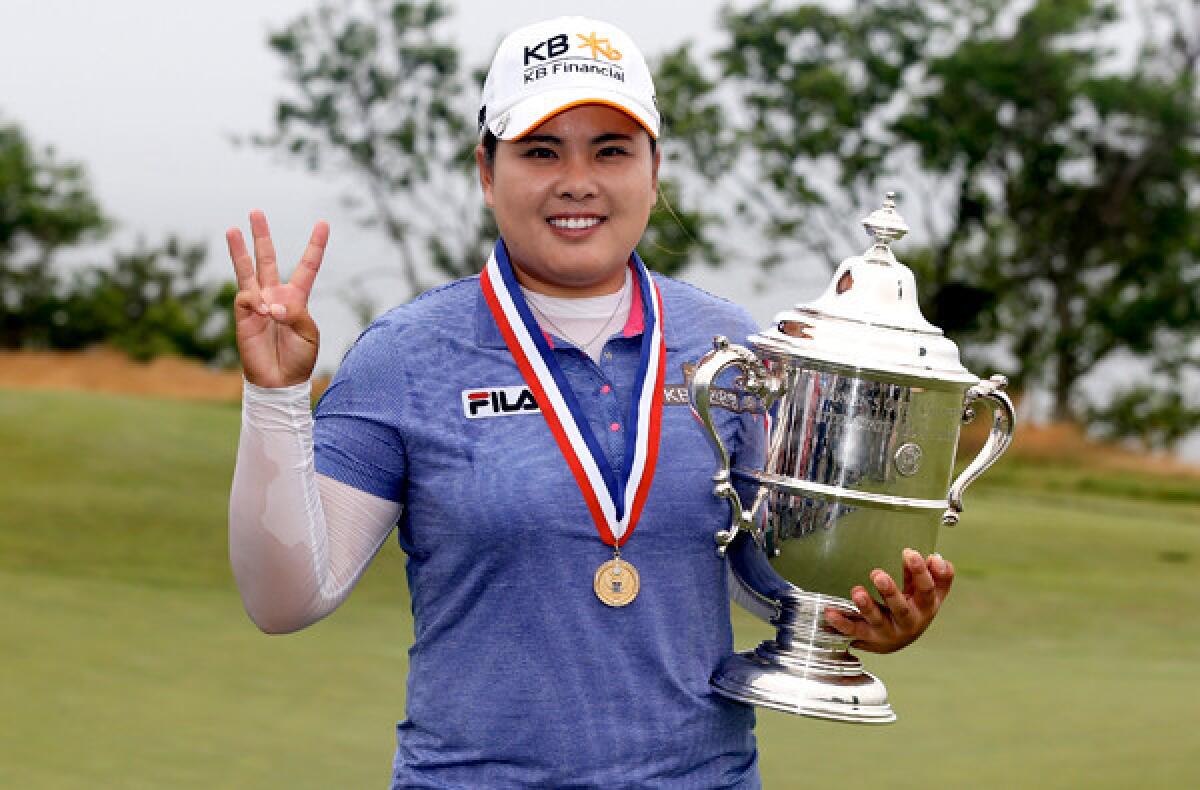 Inbee Park flashes three fingers as she poses with the winner's trophy at the U.S. Women's Open on Sunday at Sebonack Golf Club in Southampton, N.Y.