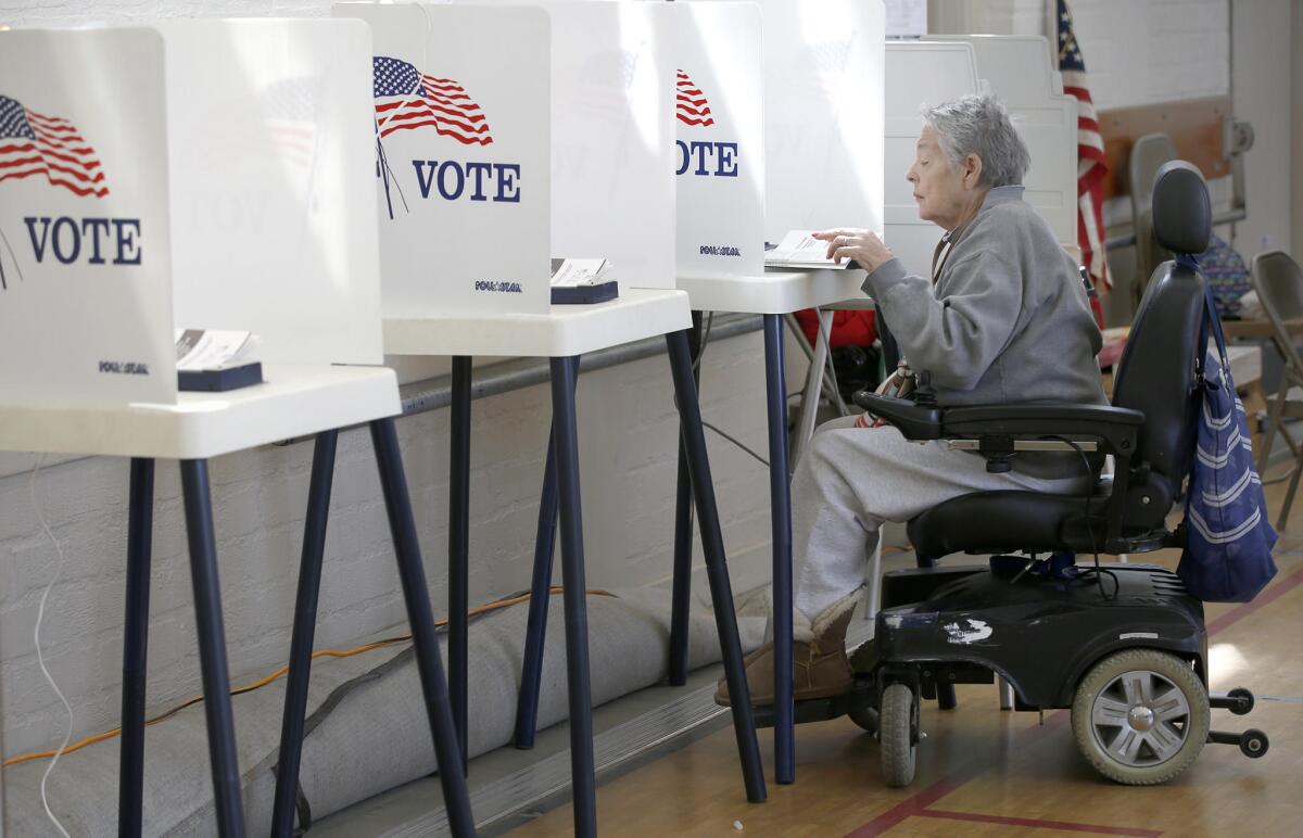 After traveling a mile in her wheelchair, Ro Betancourt, 78, casts her ballot at the Hollywood Recreation Center.