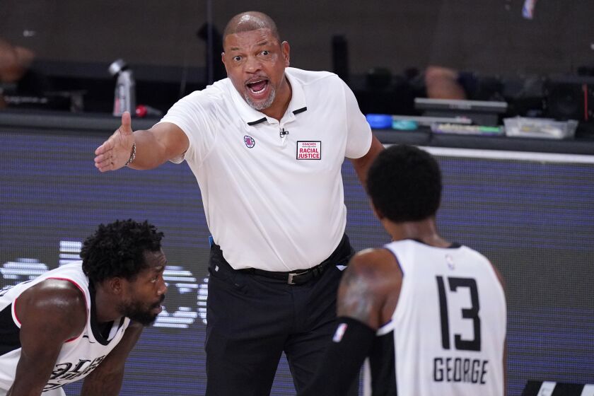Los Angeles Clippers head coach Doc Rivers, top, talks with Paul George (13) during the second half of an NBA conference semifinal playoff basketball game Monday, Sept. 7, 2020, in Lake Buena Vista, Fla. (AP Photo/Mark J. Terrill)