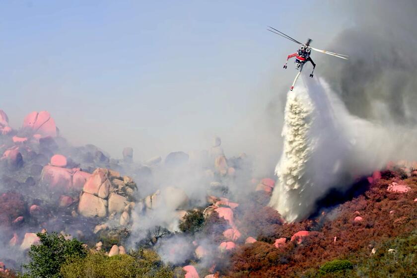 A CAL FIRE/San Diego County Fire water tanker helicopter makes a drop on a fire in Potrero.