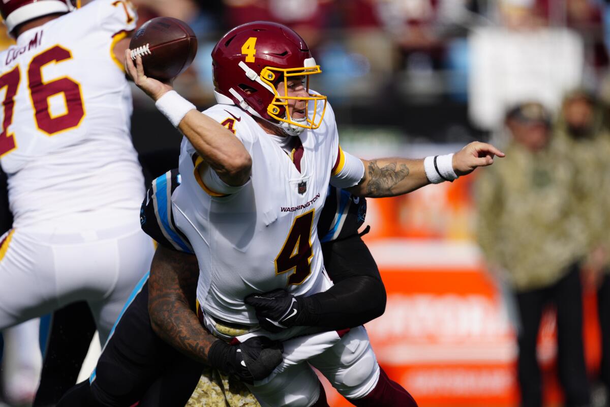 Washington quarterback Taylor Heinicke is tackled by Carolina Panthers cornerback Stephon Gilmore.