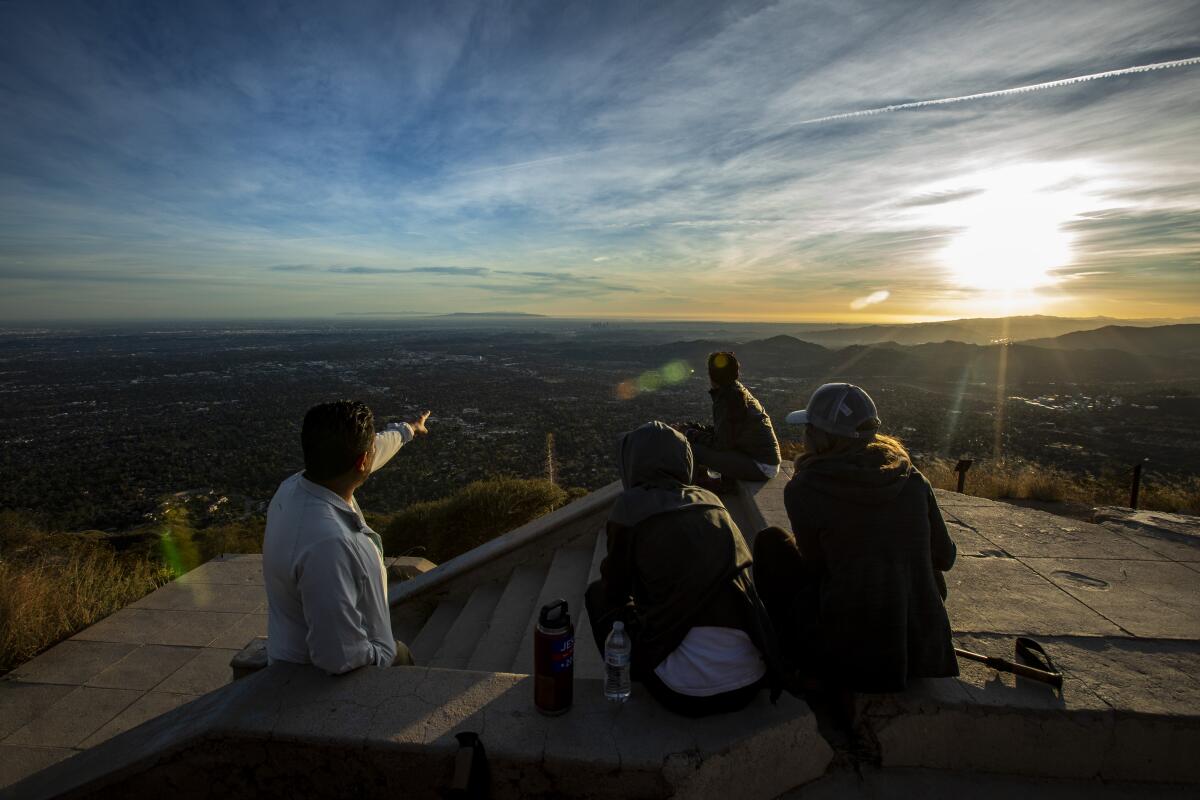 Hikers take in the sunset from the steps of the hotel ruins atop Echo Mountain.