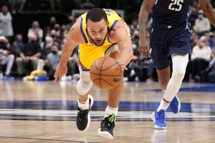 Golden State Warriors guard Stephen Curry (30) works to keep control of the the ball during the second half of an NBA basketball game against the Dallas Mavericks in Dallas, Wednesday, Jan. 5, 2022. (AP Photo/LM Otero)