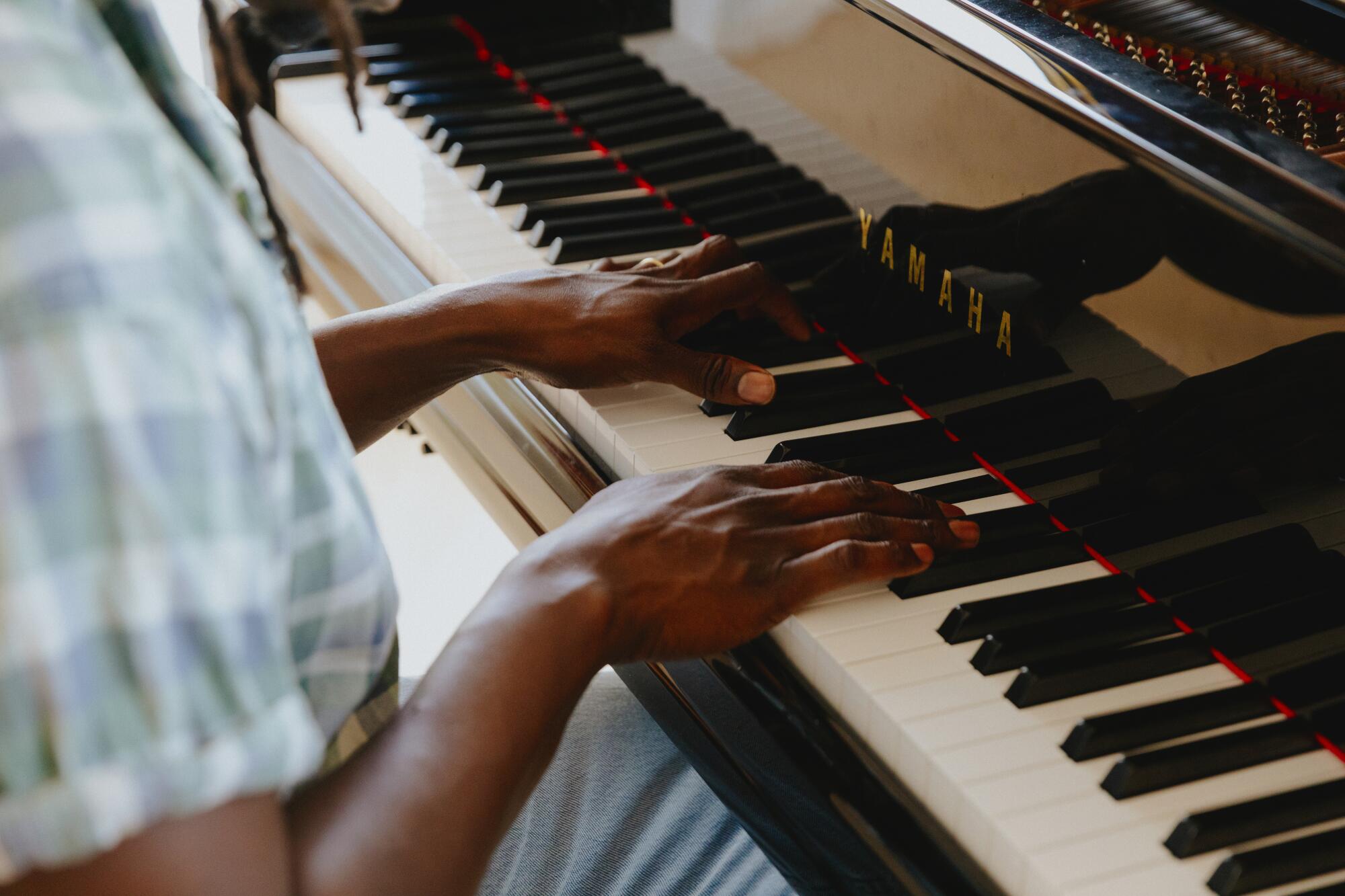 The hands of a man in piano keys.