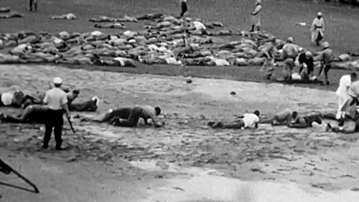 A scene from "Attica" shows dozens of prisoners lying face-down on the ground. 
