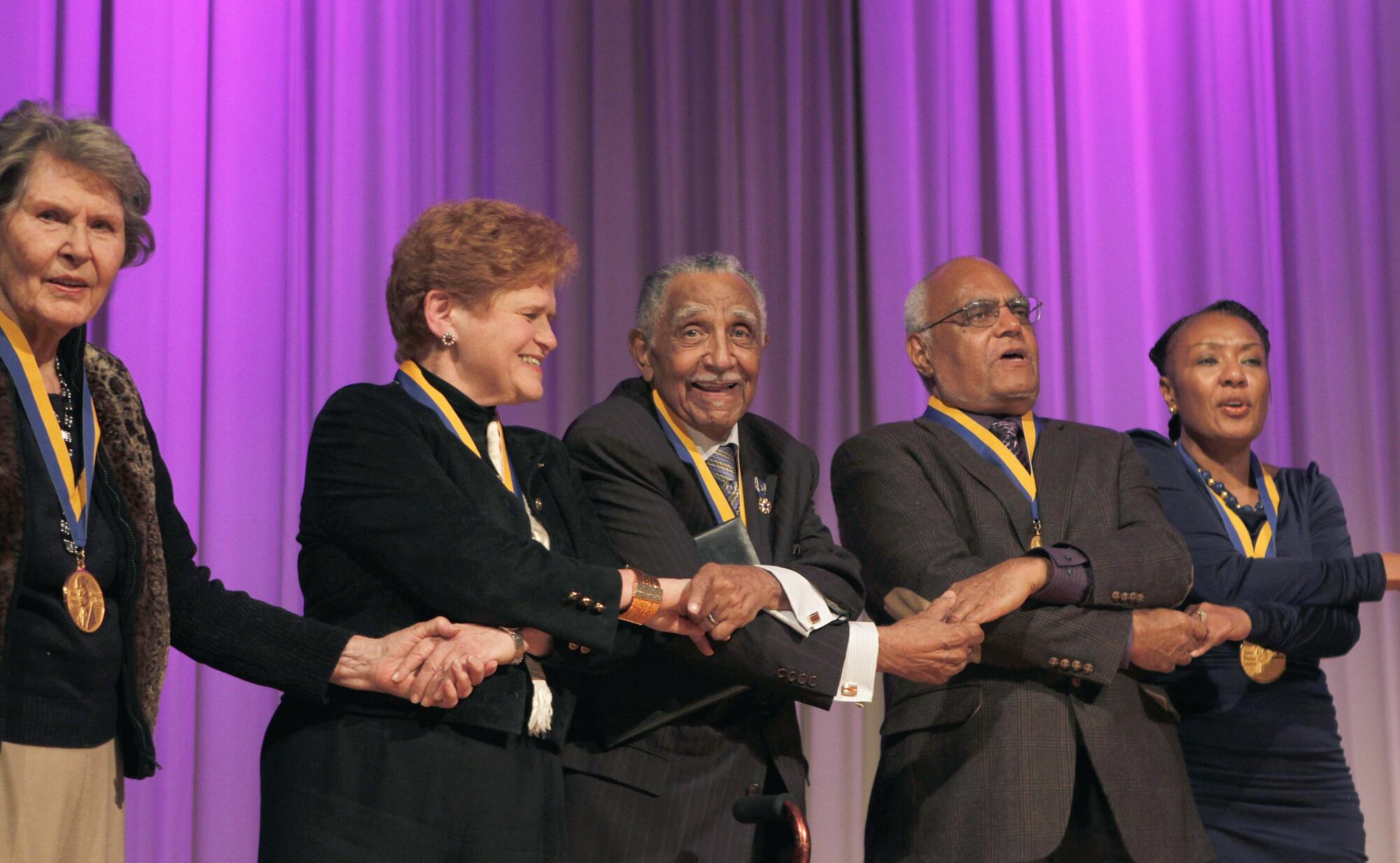 Five honorees holding hands onstage