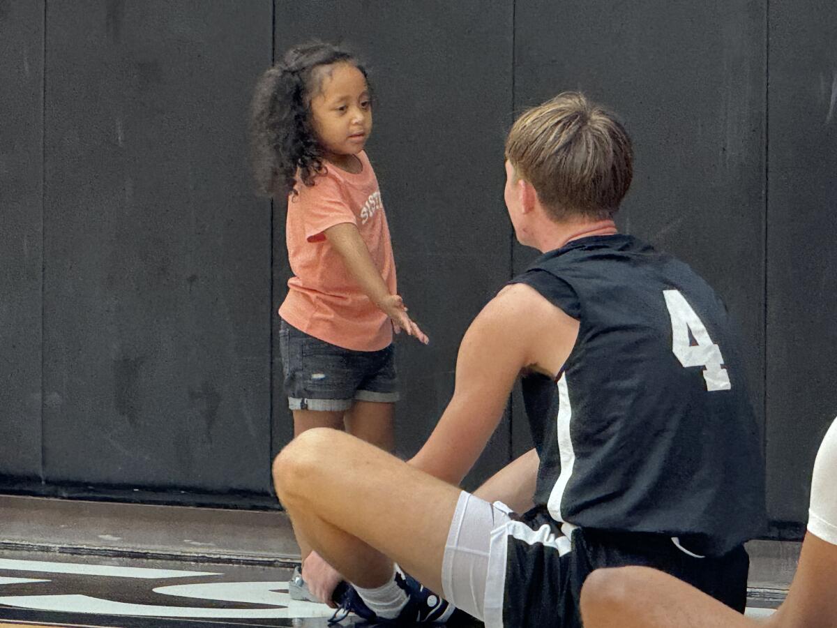 The daughter of a Harvard-Westlake assistant coach Ed Estavan gives attention to Nikolas Khamenia.