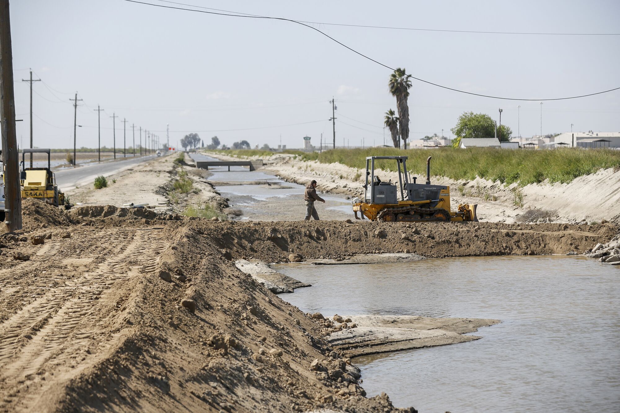  Crews repair a damaged drainage channel.