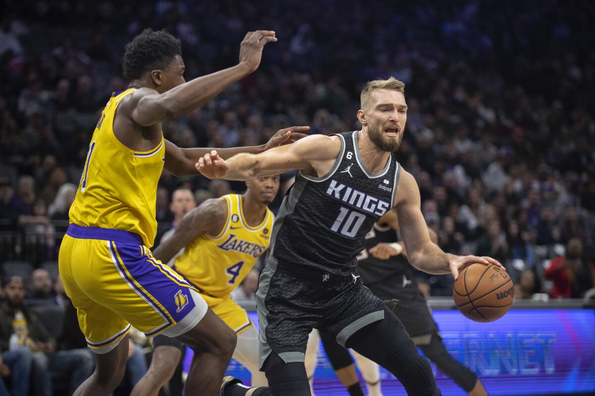 Sacramento Kings forward Domantas Sabonis is defended by Lakers center Thomas Bryant.