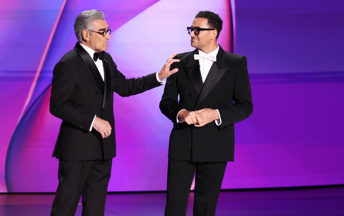 two men in glasses and formal attire onstage