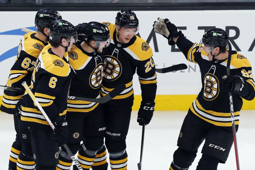 Boston Bruins' Anton Blidh, center left, celebrates his goal with teammates Mike Reilly (6), Jakub Zboril (67) Curtis Lazar (20) and Tomas Nosek (92) during the first period of an NHL hockey game against the Vancouver Canucks, Sunday, Nov. 28, 2021, in Boston. (AP Photo/Michael Dwyer)