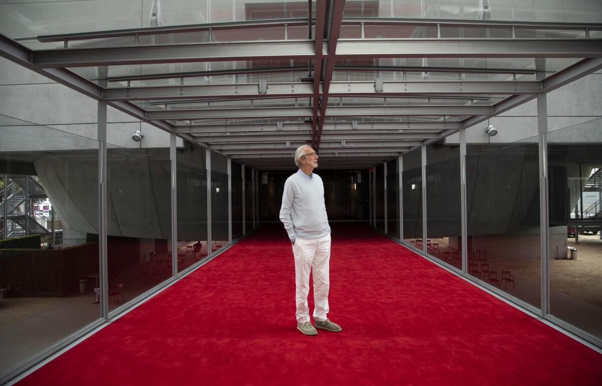 Renzo Piano looks into the distance while standing on the red-carpeted bridge that leads to the Geffen Theater.