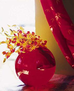 Orchids in a red glass fishbowl