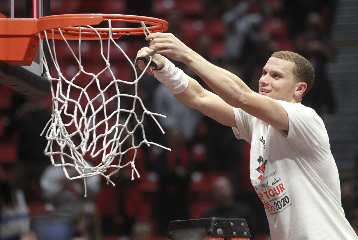 SDSU guard Malachi Flynn takes his turn to cut the net after the Aztecs defeated New Mexico 82-59 at Viejas Arena on Tuesday.