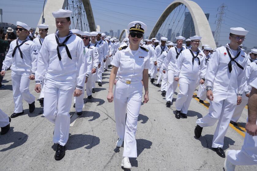 Sailors of the USS Carl Vinson walk across the Sixth Street Viaduct connecting downtown Los Angeles with the Boyle Heights neighborhood Monday, May 27, 2024, in Los Angeles. (AP Photo/Ryan Sun)