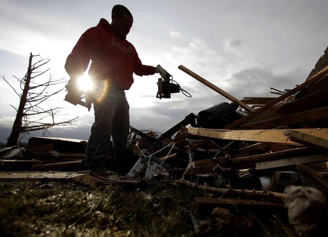 Zac Woodcock salvages items from the rubble of his tornado-ravaged rental home in Moore, Okla.