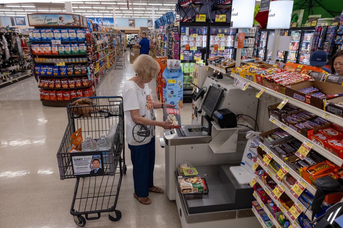 Uma mulher usa o sistema de auto-checkout.