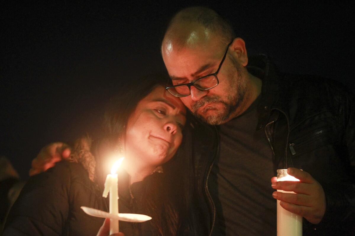 Ruben Gala and Jessica Rosario, both cousins of Sabrina Rosario, who was killed along with her four sons in a domestic murder-suicide last weekend, embrace during a candlelight vigil at the Paradise Hills United Church of Christ on Nov. 22.