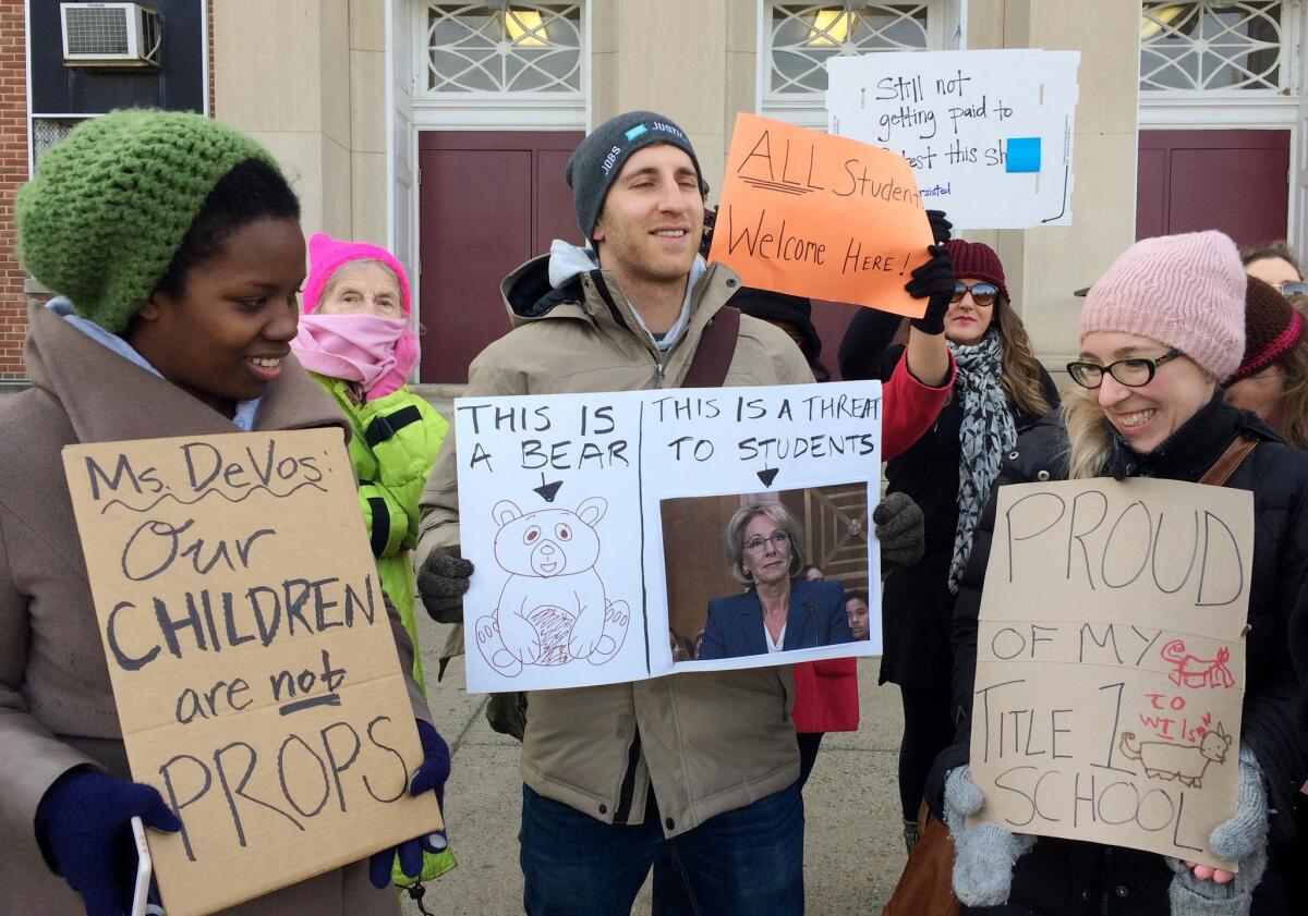 Protesters, including Ari Schwartz, center, gather outside Jefferson Middle School in Washington, D.C., where Betsy DeVos paid her second visit as Education secretary.