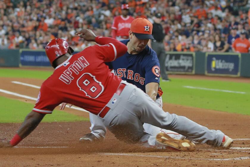 Houston Astros' pitcher Charlie Morton is late on the tag as Los Angeles Angels Justin Upton scores on a wild pitch in the first inning of a baseball game Sunday, Sept. 23, 2018, in Houston. (AP Photo/Richard Carson)