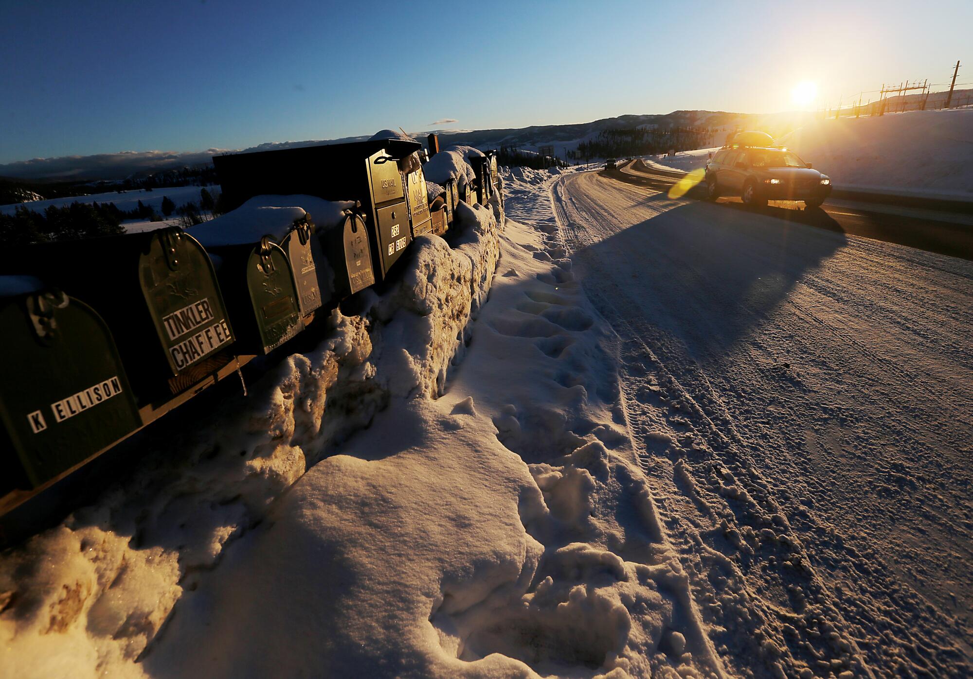 A motorist drives on Highway 24 in the snow-covered landscape near Granby, Colo.