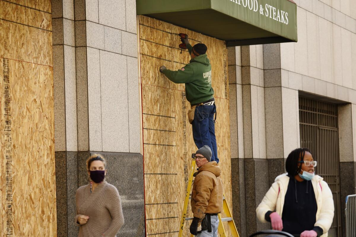 Workers board up the windows of a Philadelphia business.