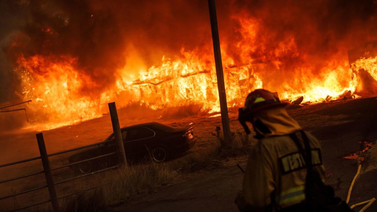 A barn is engulfed in flames as the River fire, part of the Mendocino Complex, spreads with the wind near Hendricks Road in Lake County, Calif., on July 31.