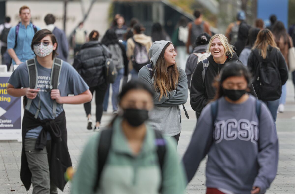 Students, including Mariah Melendez,Middle and Shelby Thompson, walk to class at UCSD.