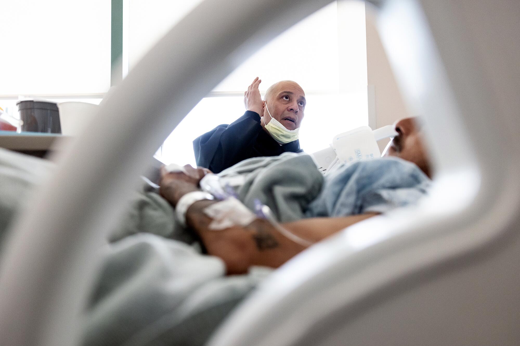 Father Cesar Galan, a hospital chaplain at St. Francis Medical Center in Lynwood, prays over patient Jose Barraza Parra.