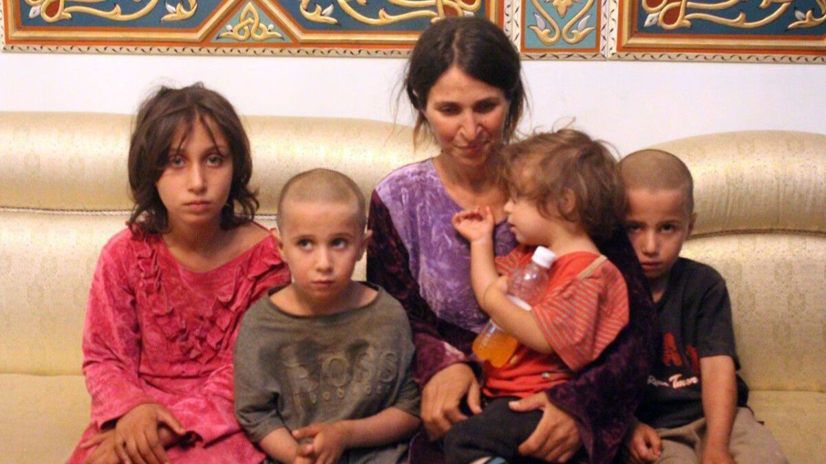A handout picture released by the Syrian Arab News Agency shows a woman and four children who were among six released Oct. 20, 2018, by the Islamic State group in a prisoner swap with the Syrian government and ransom, in Syria's southern city of Sweida.