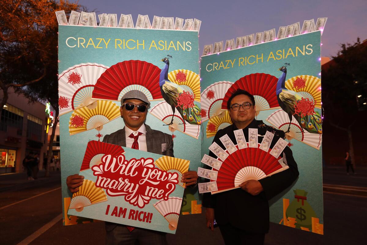 Edwin Santiago, left, and Alexis Monsanto are the poster men for "Crazy Rich Asians" at the Halloween Carnaval.