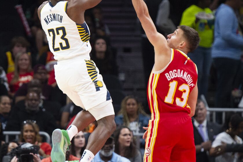Indiana Pacers forward Aaron Nesmith shoots over Atlanta Hawks guard Bogdan Bogdanovic during the first half of an NBA basketball game, Saturday, March 25, 2023, in Atlanta. (AP Photo/Hakim Wright Sr.)