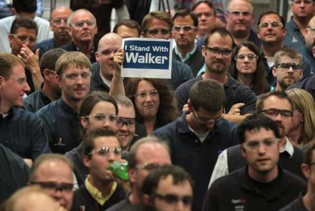 A worker at Quad Graphics shows her support during a campaign stop by Wisconsin Governor Scott Walker in Sussex, Wisconsin. Walker faces Democratic contender Milwaukee Mayor Tom Barrett in a recall election on June 5.