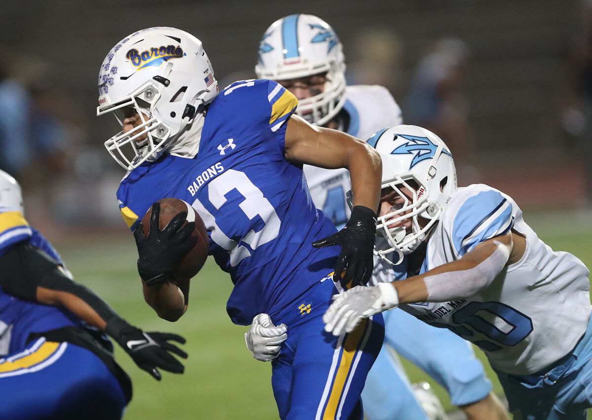 Fountain Valley's Nolan Oliveras (13) makes a first down run during a Sunset League football opener against CdM on Thursday.