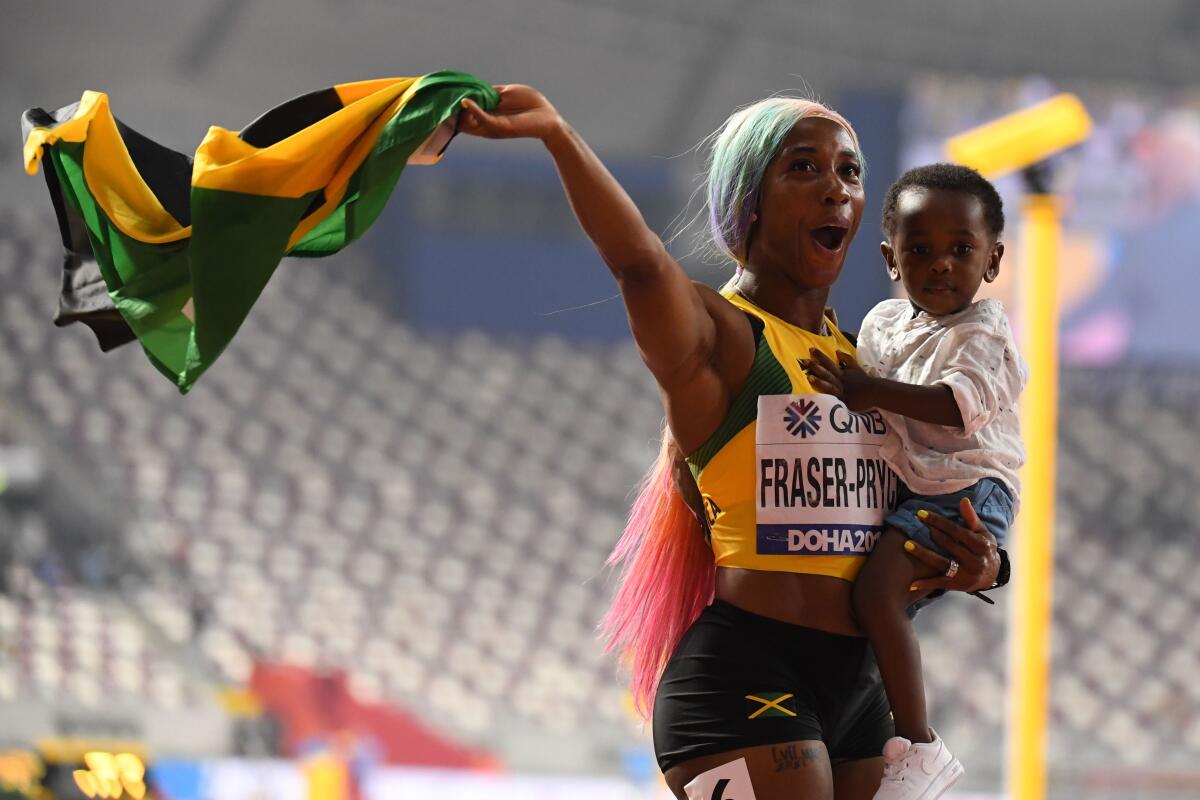 Jamaica's Shelly-Ann Fraser-Pryce celebrates with her son after winning the women's 100-meter final Sunday.