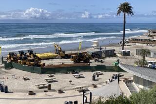 A crew from Manson Construction assembles equipment Thursday at Moonlight Beach to begin sand replenishment in Encinitas.