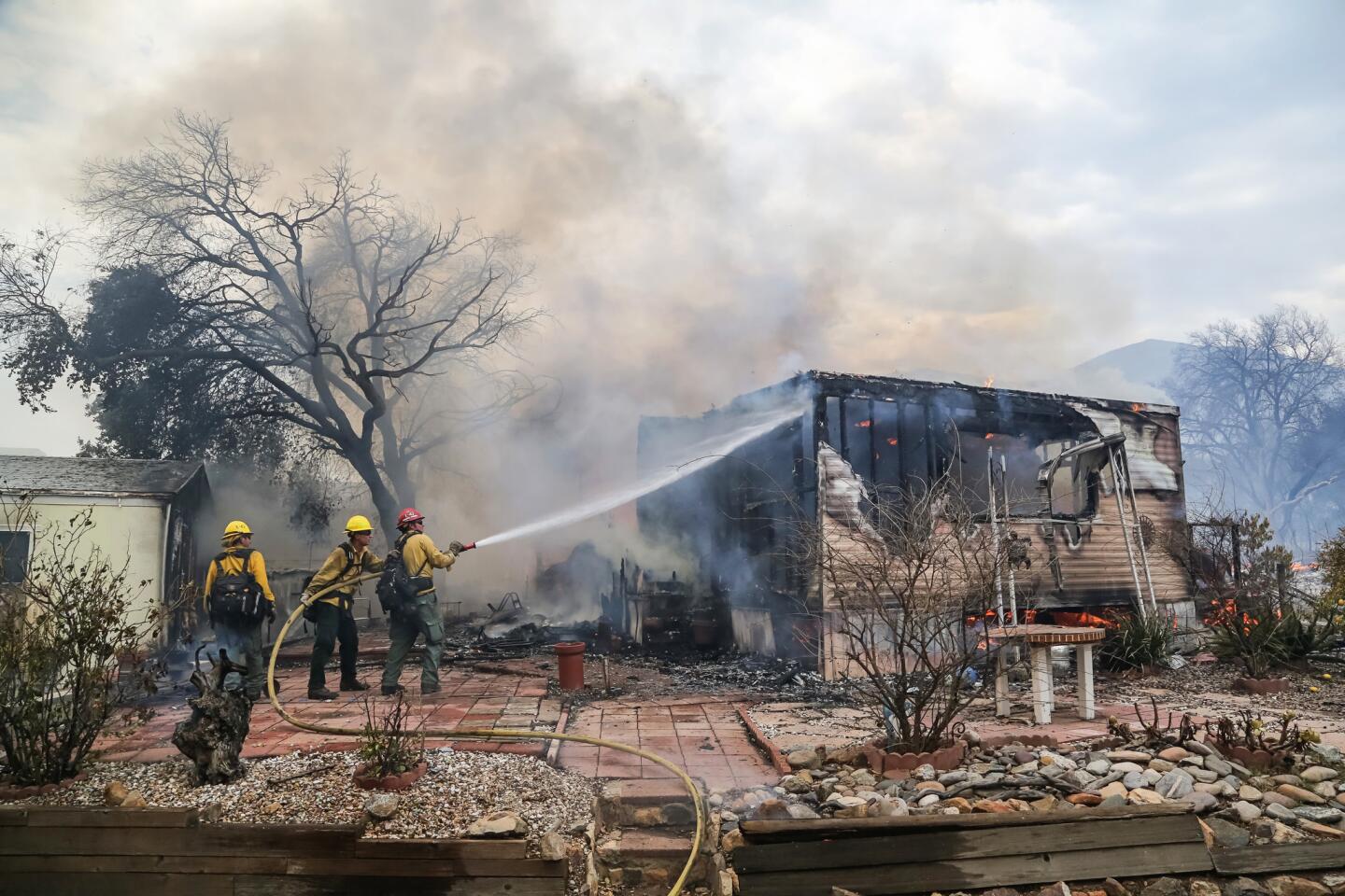 Firefighters battle flames at the Alpine Oaks Estates mobile home park on Friday during a fire in Alpine, California.