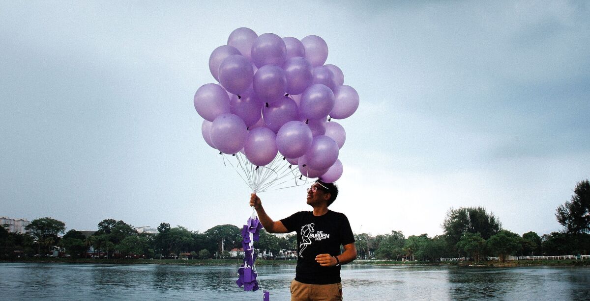 A volunteer from a nongovernmental organization called Malaysians for Malaysia gets ready to release balloons in Kuala Lumpur in honor of the passengers and crew aboard missing Malaysia Airlines Flight 370.