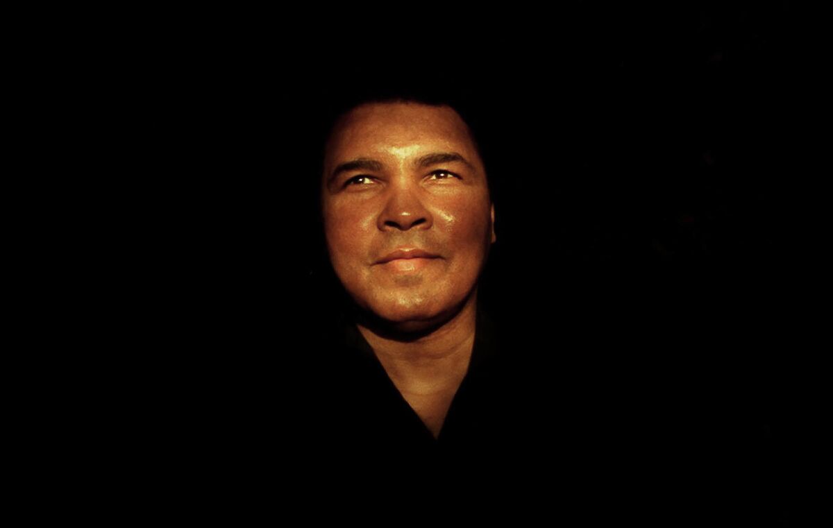 Dec. 19, 1996: Muhammad Ali standing in a ray of light for photographers attending photo exhibit for Howard Bingham in Watts.