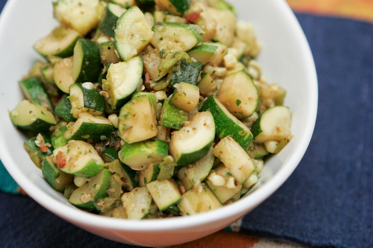 Zucchini, corn and green chile served in a white bowl.