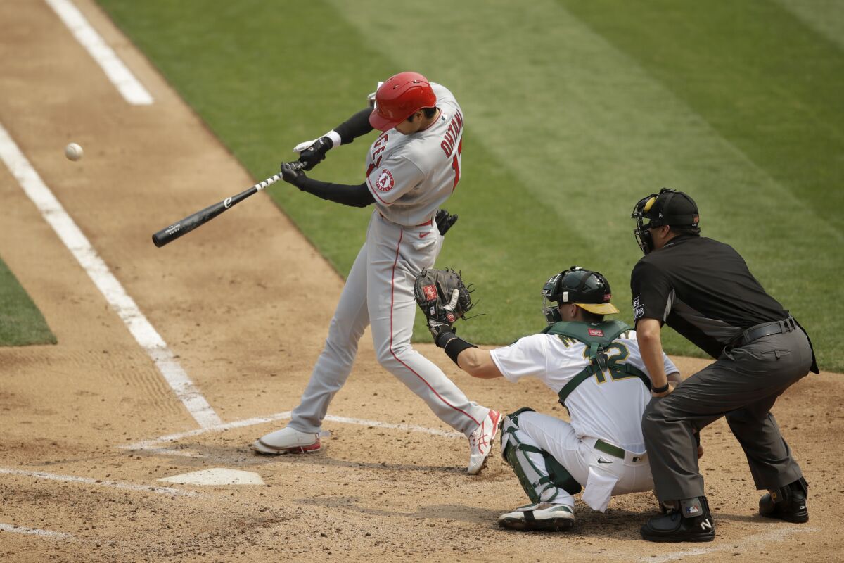 Angels designated hitter Shohei Ohtani swings for a three-run home run.